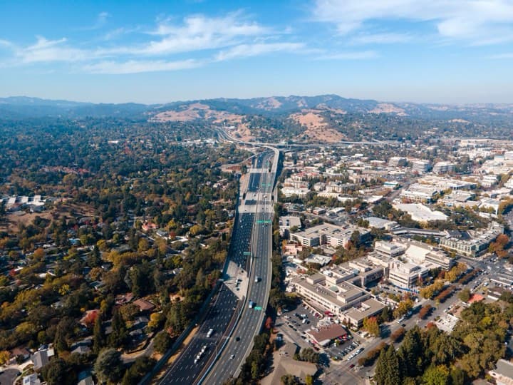 Aerial view of a metro region with a highway through the suburbs